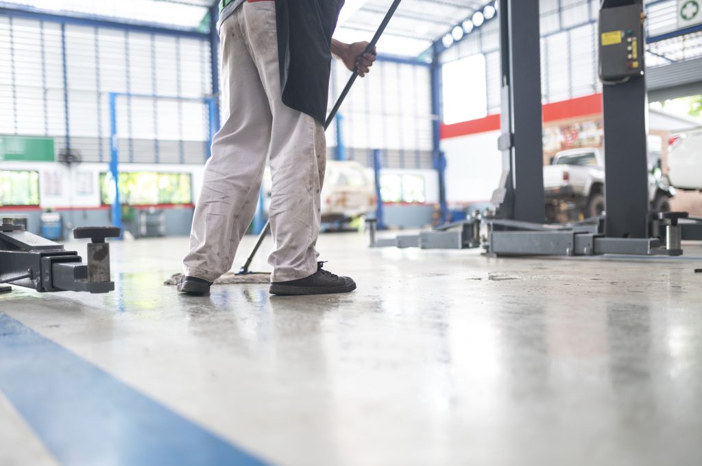 Two cleaners mopping a warehouse floor
