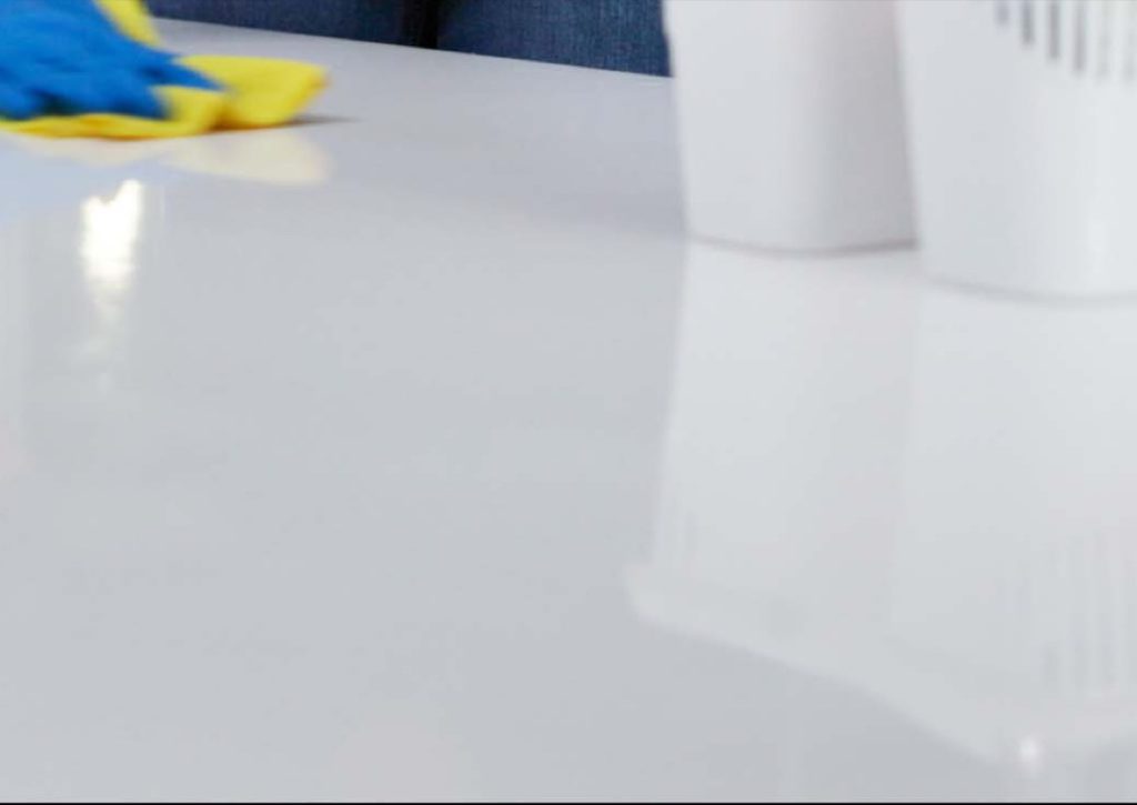 Gloved hand wiping a white counter