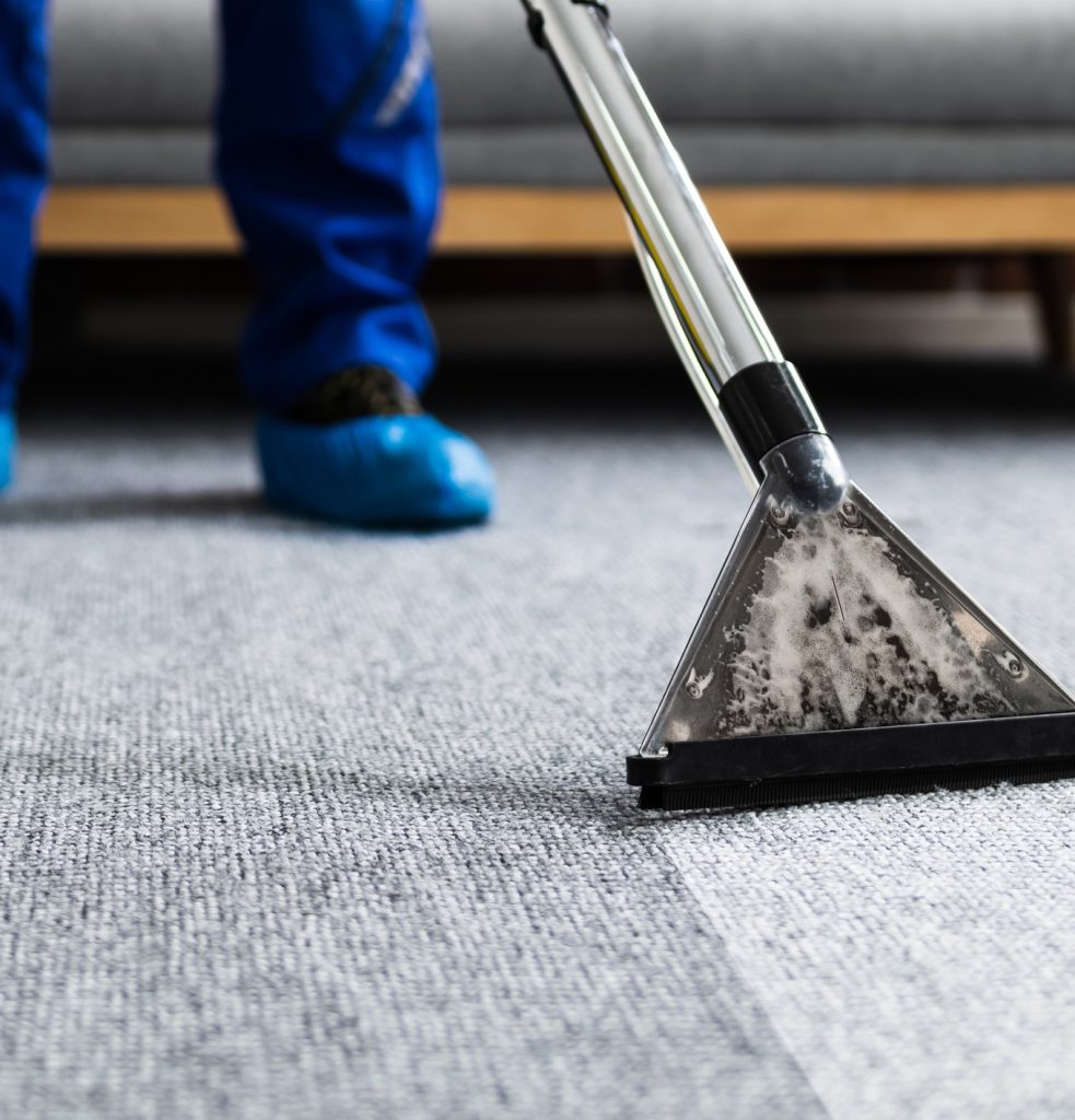 Carpet extractor wand being drawn across a grey carpet
