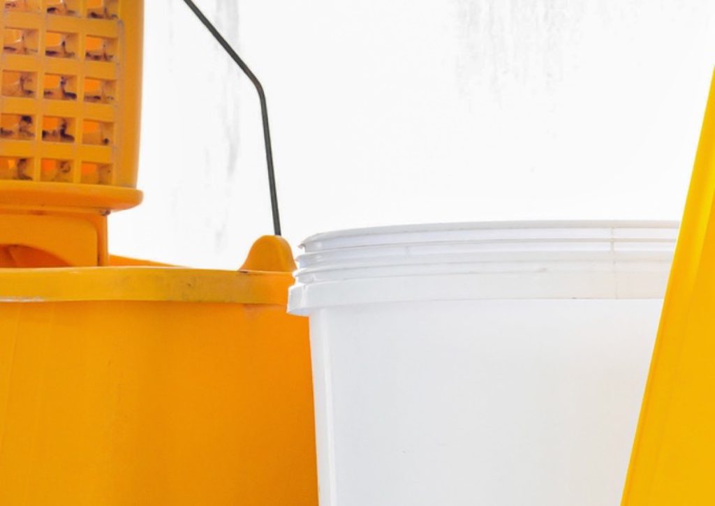 Yellow mop bucket beside a white pail