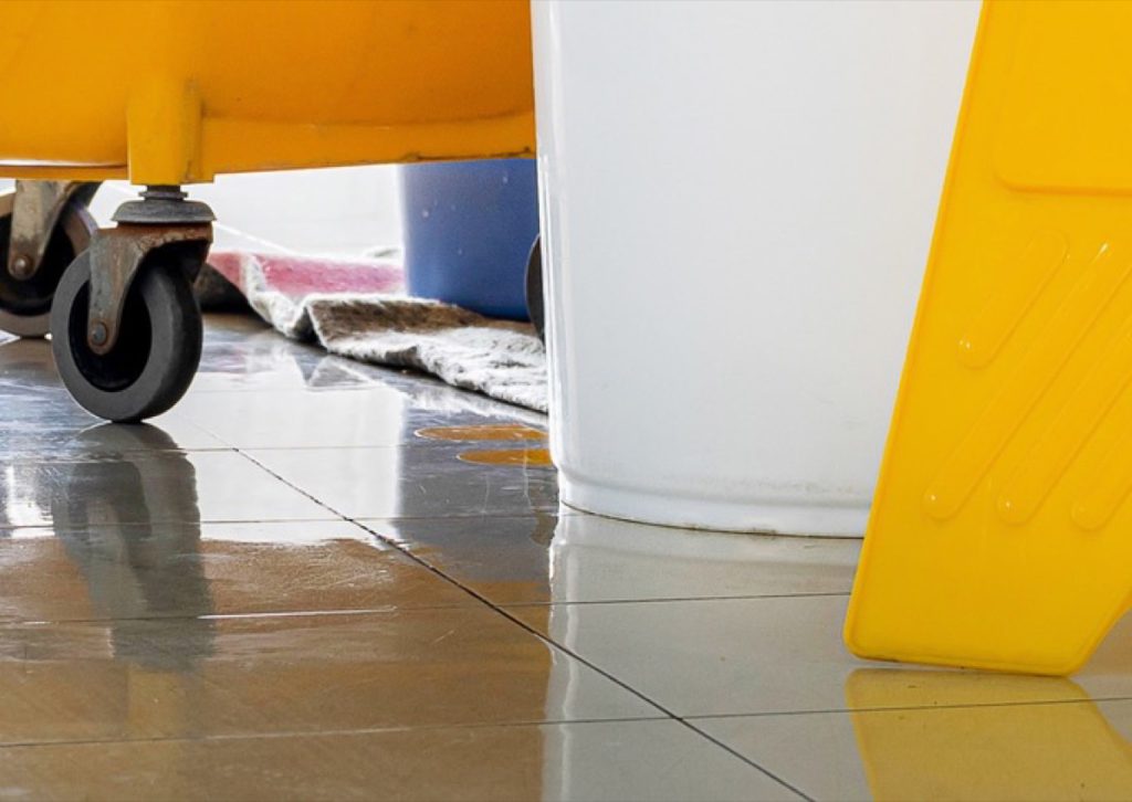 Mop bucket wheels on a wet tiled floor