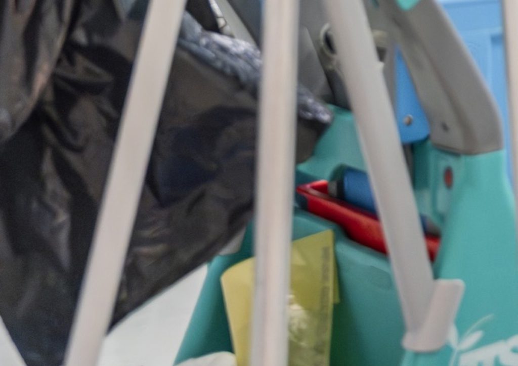 Waste bag and mop handles on a cleaning cart