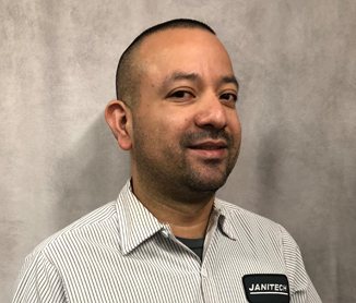Studio headshot of Geovanny Bonilla in a striped shirt with a Janitech name badge